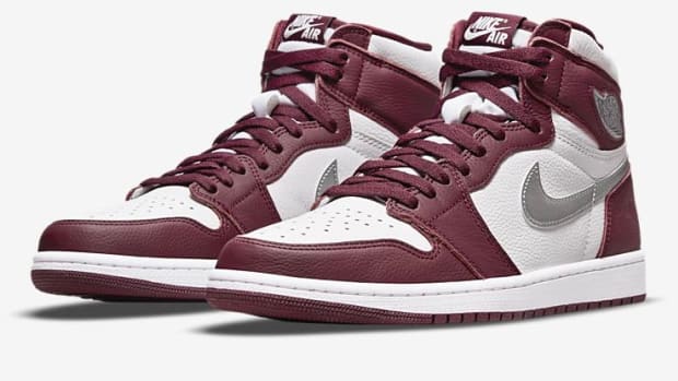 View of maroon and silver Jordan 1 shoes.